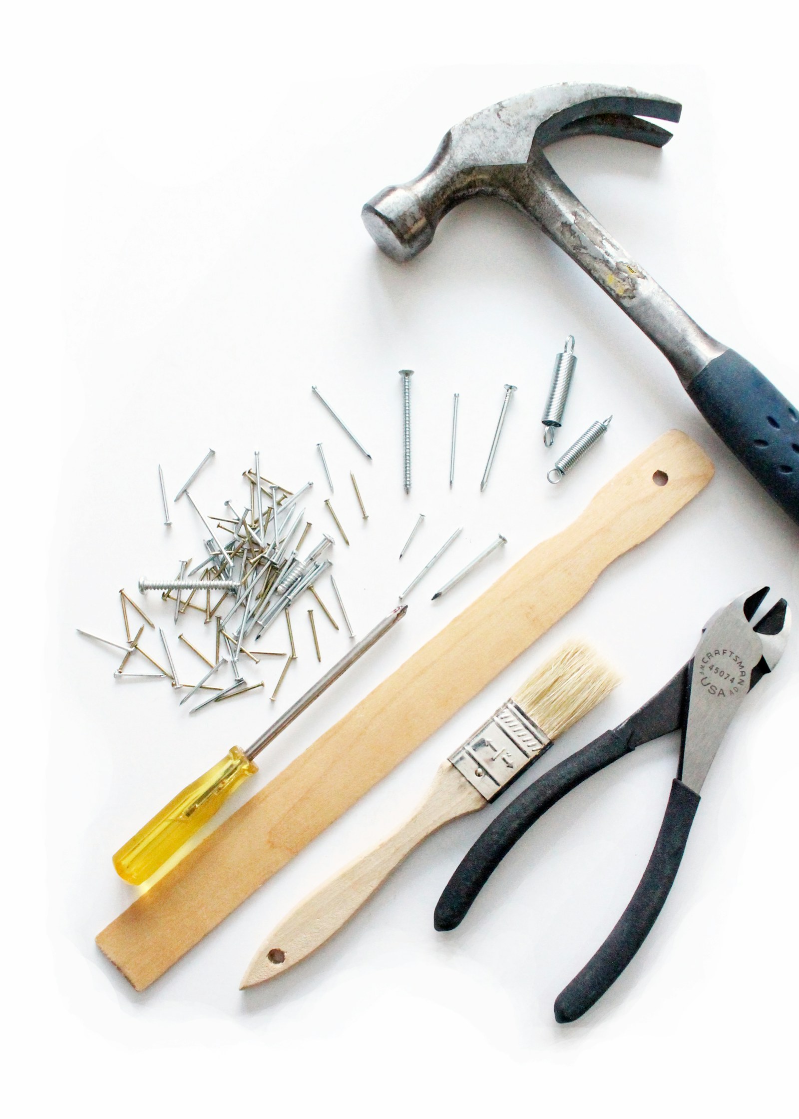 Basic hand tools laid out beside flat-pack furniture in an apartment.
