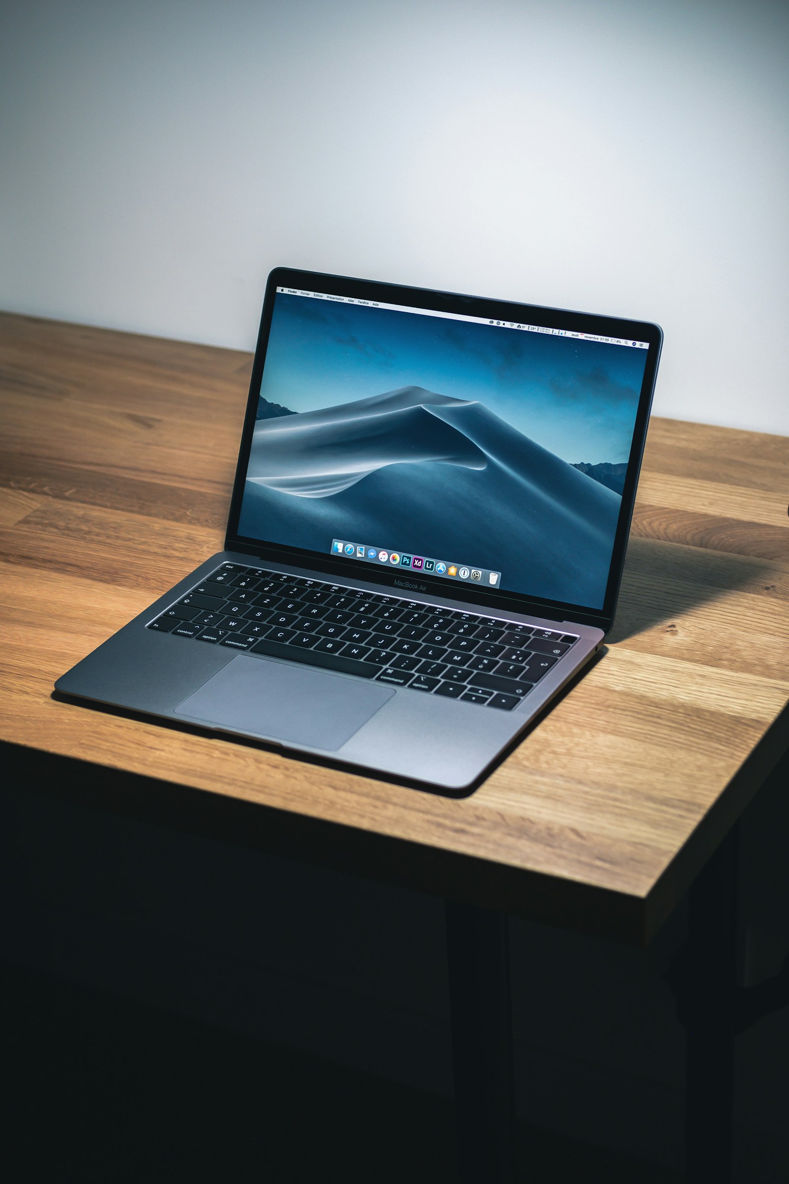 Laptop raised on a slim stand in a lived-in home office.